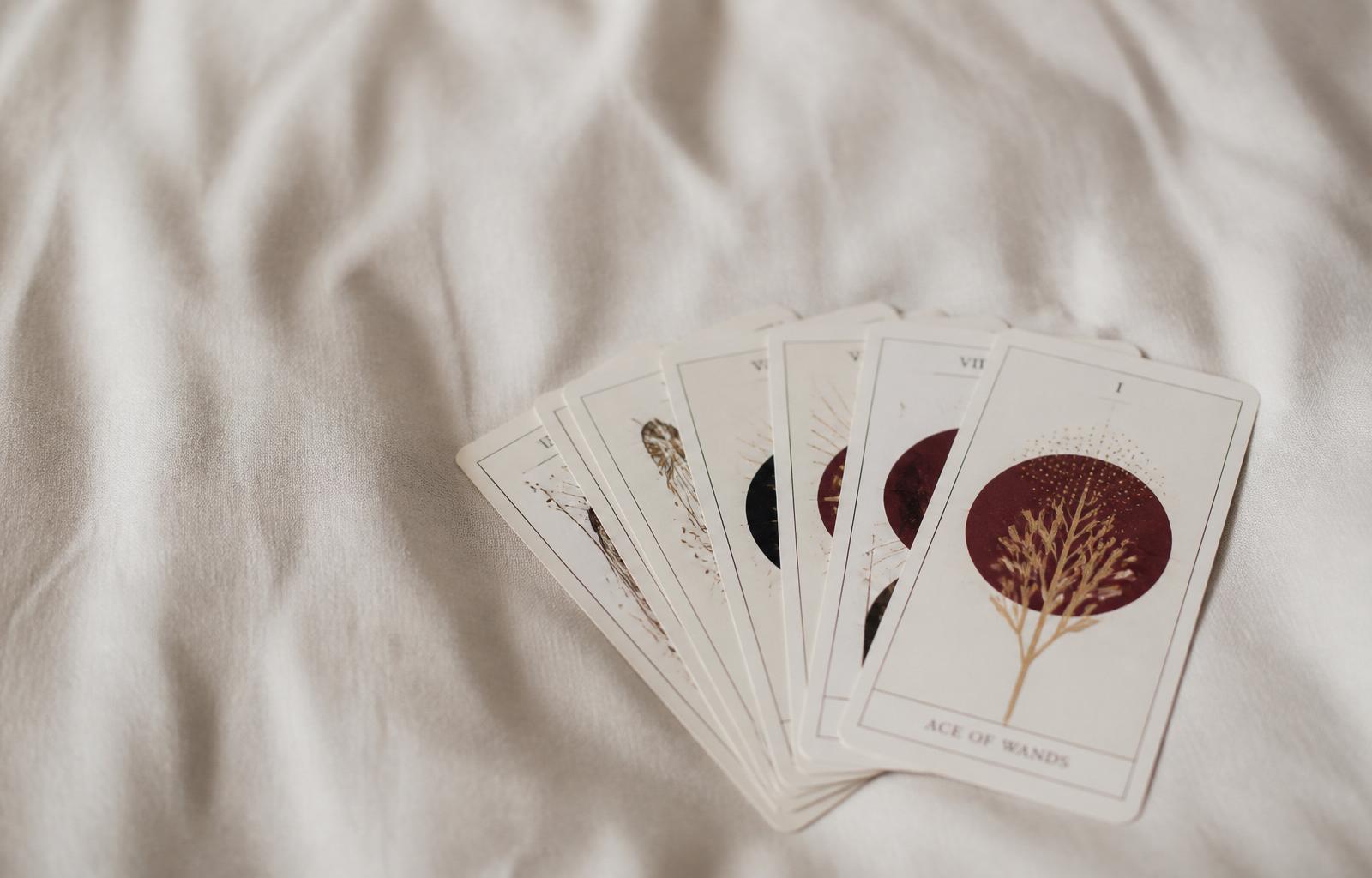 Cartes de tarot disposées en éventail sur une nappe en velours bordeaux, atmosphère tamisée